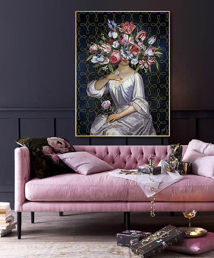 Beautiful Dreamer by Jackie von Tobel, a print of a woman who is blinded by an explosion of flowers shaped like a headdress, in a room setting hanging above a lovely modern pink sofa.